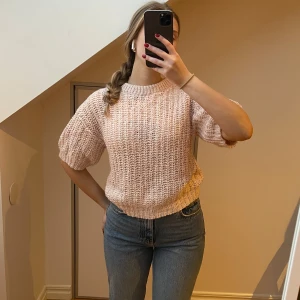 Rosa stickad T-shirt - Säljer en mysig rosa stickad tröja med korta ärmar. Perfekt för en avslappnad stil och passar bra till jeans. Tröjan har en rund halsringning och ribbade kanter. Från Lindex.🩷