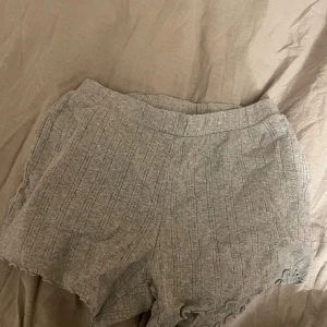 Grå shorts med spetsdetaljer - Snygga grå shorts med spetsdetaljer längs kanten. De har en bekväm passform och passar perfekt att sova i. Dessa är från cubus och är inte använda.