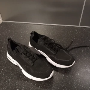 Svarta sneakers med vit sula - Snygga svarta sneakers med vit sula och snörning. Använt dem 1 gång. 