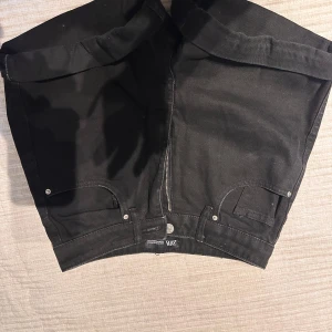 Svarta shorts från Zara - Snygga svarta shorts från Zara med dragkedja och knapp framtill. Klassisk design med fickor både fram och bak. Perfekta för en stilren look.