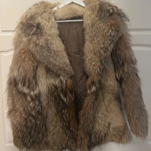 Brun pälsjacka - Säljer en lyxig brun pälsjacka med naturliga nyanser och mjuk textur. Jackan har en klassisk design med långa ärmar och en elegant krage. Perfekt för att hålla sig varm och stilren under kyliga dagar.