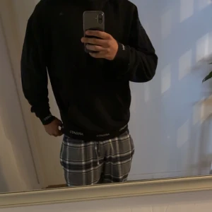 Svart tröja från Arigato - Säljer en stilren svart tröja från Arigato med deras logga tryckt längs nederkanten. Tröjan har en normal passform och långa ärmar, perfekt för en avslappnad look.