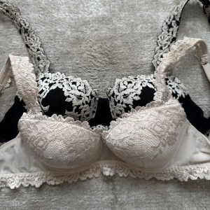 Intimissmi spetsbehåar  - Säljer två eleganta behåar med spetsdetaljer. Den ena är svart med vit spets och den andra är beige med matchande spets. Helt oanvända! Storlek 75B på båda!