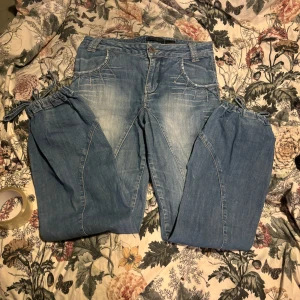 Blå jeans med knytband - Snygga blå jeans från Only med unika knytband vid bensluten. De har en klassisk femficksdesign och ljusa tvättade detaljer. Perfekta för en avslappnad stil.