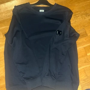 Svart tröja från C.P. Company - Säljer en stilren svart tröja från C.P. Company. Denna tröjan är använd en gång men fortfarande i toppskick 