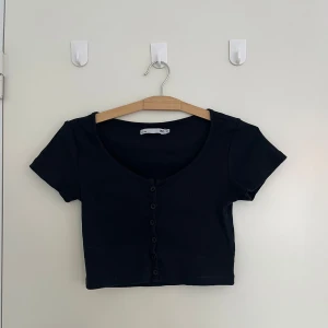 Svart croppad topp - Snygg svart croppad topp från Lager 157. Har knappar framtill. Sitter som en magtröja🌸