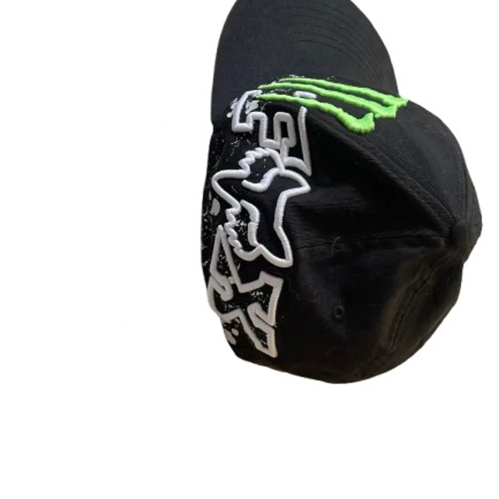 Cool svart keps med grönt Monster Energy-märke och vit Fox-logga. Perfekt för streetwear eller casual outfits. Flexfit-design för bekväm passform. Kepsen har en platt skärm och är i bra skick. Passar perfekt för dig som gillar att sticka ut!. Accessoarer.