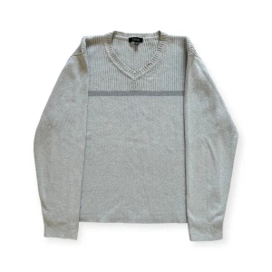 Grå tröja från Clifton - Säljer en stilren grå tröja från Clifton i storlek M. Tröjan har en v-ringad hals och ribbade detaljer vid halsen och axlarna. Perfekt för både vardag och lite finare tillfällen. Skön och enkel att matcha med det mesta i garderoben! I fint skick, endast en liten fläck på höger arms baksida, se bild. 