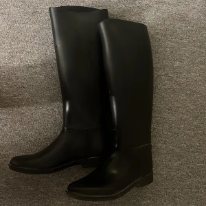 Svarta höga ridstövlar - Säljer ett par svarta ridstövlar. De är knähöga och  super sköna. Passar mest till sommar/vår då de är ganska tunna, men om man har tjocka ridstrumpor under så passar dom perfekt även till vintern. De har lite små repor, men dom syns knappt. Nästan aldrig använda. Storlek 39