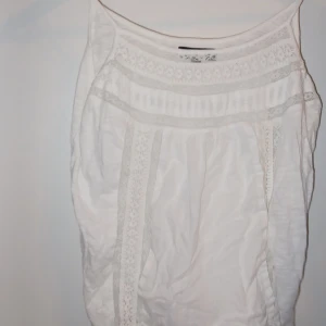 Vit blus med spetsdetaljer - Säljer en söt vit blus med fina spetsdetaljer. Perfekt för sommardagar eller en avslappnad vårlook. Blusen har en luftig passform och är superbekväm att bära. Passar både till jeans och kjol!