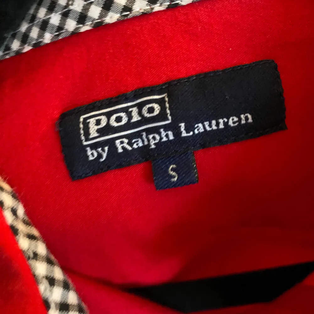 Snygg röd skjorta från Polo Ralph Lauren i storlek S men liten i storleken. Figurnära passform. Den har långa ärmar, broderad logga på bröstet och stiliga rutiga inslag vid kragen och ärmsluten. Perfekt för både vardag och fest!. Skjortor.