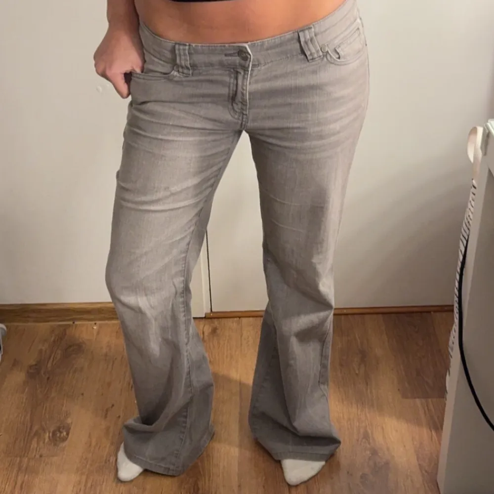 Säljer ett par snygga grå baggy low waist jeans i bra skick. De är lågmidjade och har en klassisk femficksdesign. Perfekta för både vardag och fest! Passar till allt och ger en avslappnad men stilren look.. Jeans & Byxor.