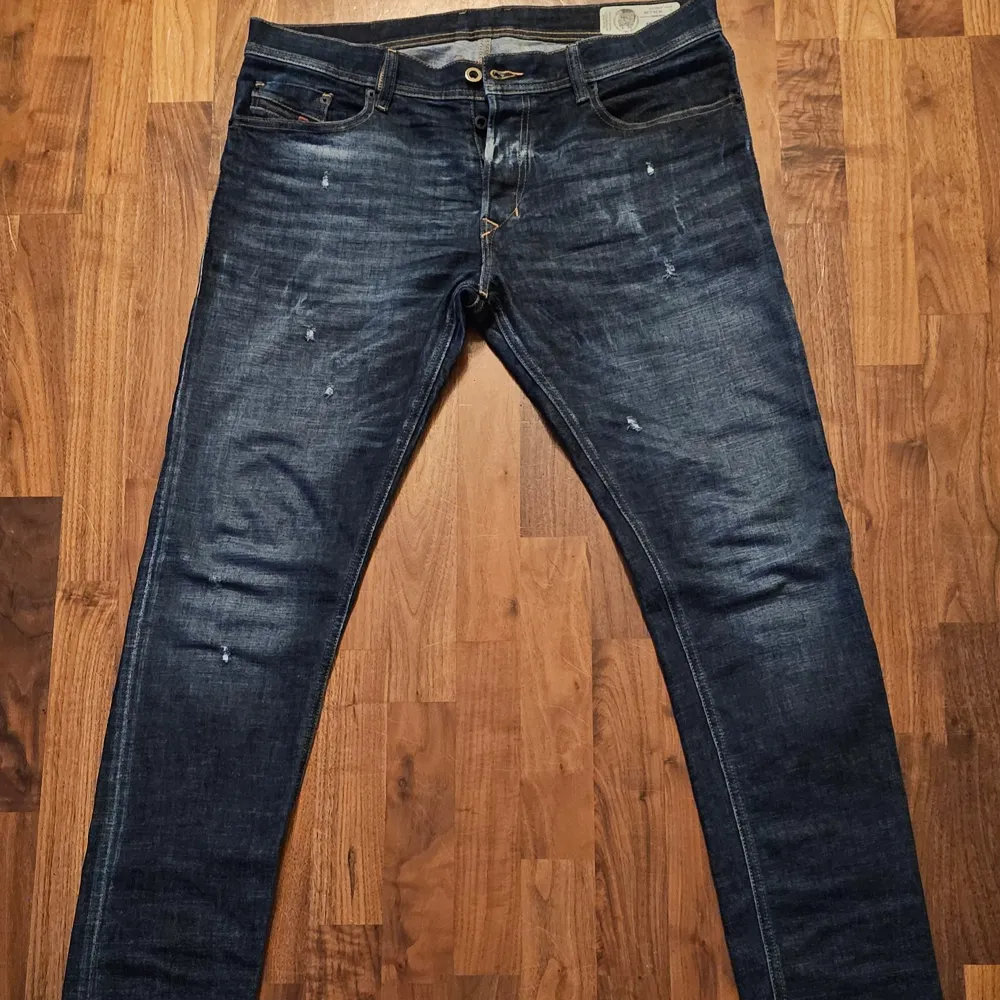 Säljer ett par snygga mörkblå jeans från Diesel, modell Tepphar. De har en slim-carrot passform och är i bra skick. Jeansen har en klassisk femficksdesign med subtila slitningar för en cool look. Perfekta för både vardag och fest!. Jeans & Byxor.