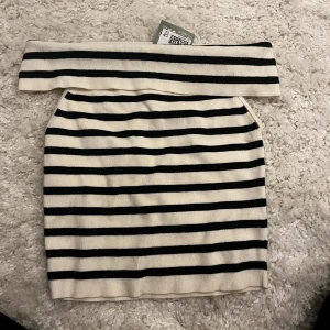 Randig kjol - Snygg randig topp i svart och vit med en tight passform. Perfekt för både vardag och fest! Toppen är i nytt skick och aldrig använd. 
