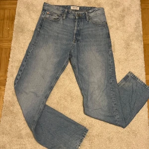 Blå jeans från Jack & Jones - Säljer ett par snygga blå jeans från Jack & Jones i modellen Loose/Chris. De har en avslappnad passform och är perfekta för en casual look. Jeansen är i bra skick och har klassiska fem fickor samt knappgylf. Perfekta för både vardag och chill. Pris kan diskuteras!! (Andvända fåtal gånger)