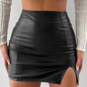 Svart skinnkjol med slits - Snygg svart skinnkjol i kort modell med en liten slits framtill. Kjolen har en tight passform och en dragkedja baktill för enkel på- och avtagning. Perfekt för en utekväll eller fest! 🖤