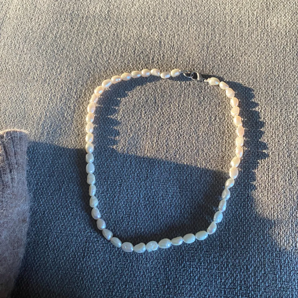 Säljer ett elegant pärlhalsband med vita pärlor. Perfekt för både vardag och festliga tillfällen. Halsbandet har en klassisk design med en enkel låsning. . Accessoarer.