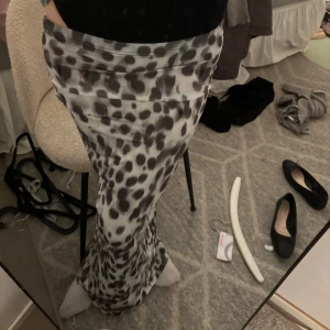 Gråmönstrad långkjol - Säljer en superfin långkjol med grått och svart mönster. Kjolen har en tight passform och är perfekt för både vardag och fest. Den är gjord i ett mjukt och bekvämt material som känns skönt mot huden. Passar perfekt till en enkel topp eller en stickad tröja.