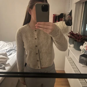 Beige kofta från Brandy Melville - Säljer en superfin beige kofta från primark i storlek XS. Den är i mycket bra skick och har en klassisk design med knappar framtill. Perfekt för höst och vår, och den är riktigt mysig att ha på sig. Passar både till vardags och lite finare tillfällen!
