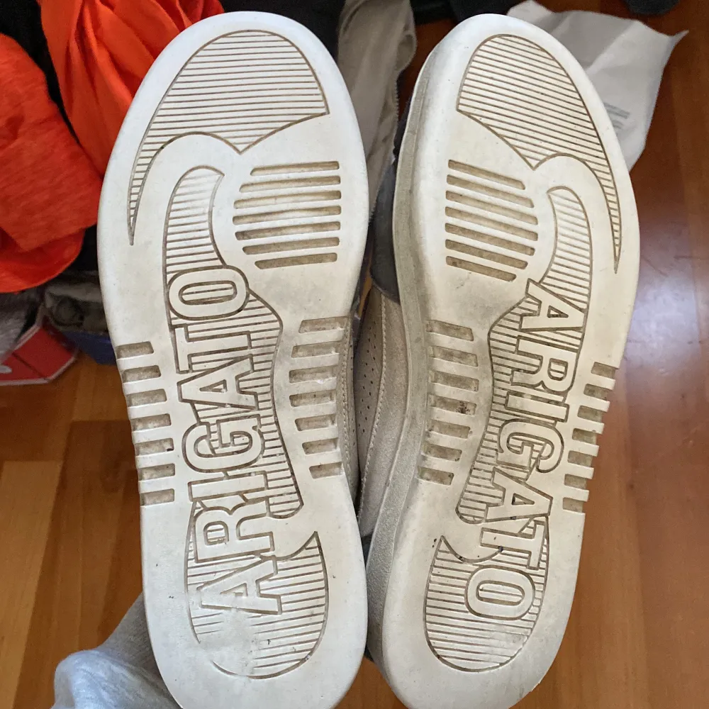 Säljer ett par stilrena sneakers från Axel Arigato i beige och grått. Skorna har snörning och en klassisk design med märkets logga på sulan. Perfekta för både vardag och fest! De är i bra skick med lite slitage på sulan. Säljer billigt pågrund av skicket, kan tänka mig att gå ner i pris. Kengät.