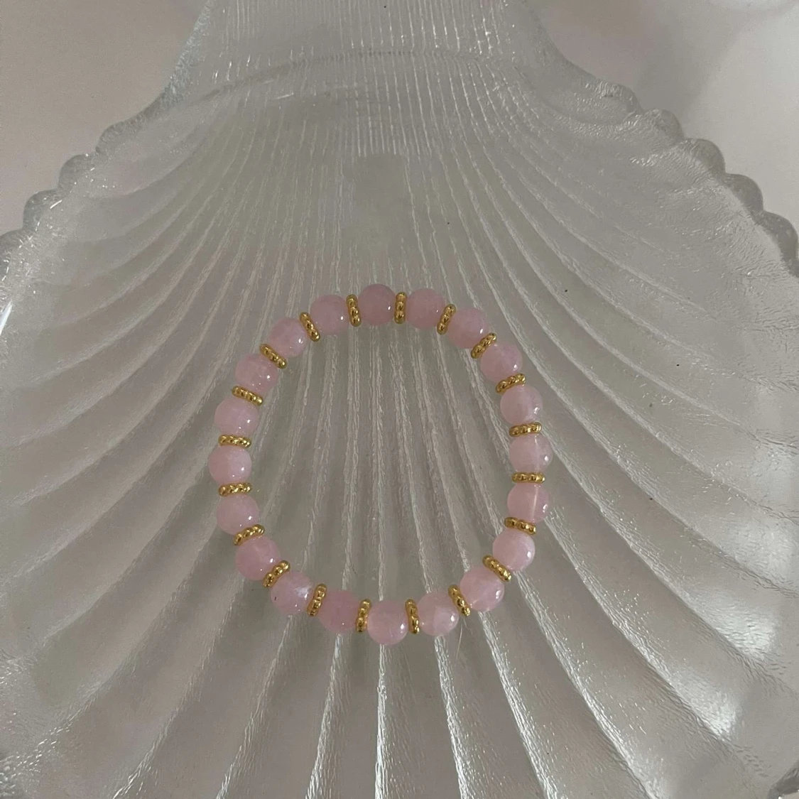 Rosa pärlarmband med gulddetaljer