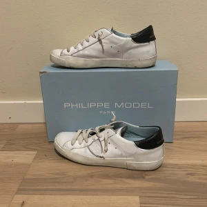 Vita sneakers från Philippe Model - Säljer ett par vita sneakers från Philip model de är i bra skick men en liten repa på högra skon på tån och lite smutsiga skickar skorna dagen efter köpet