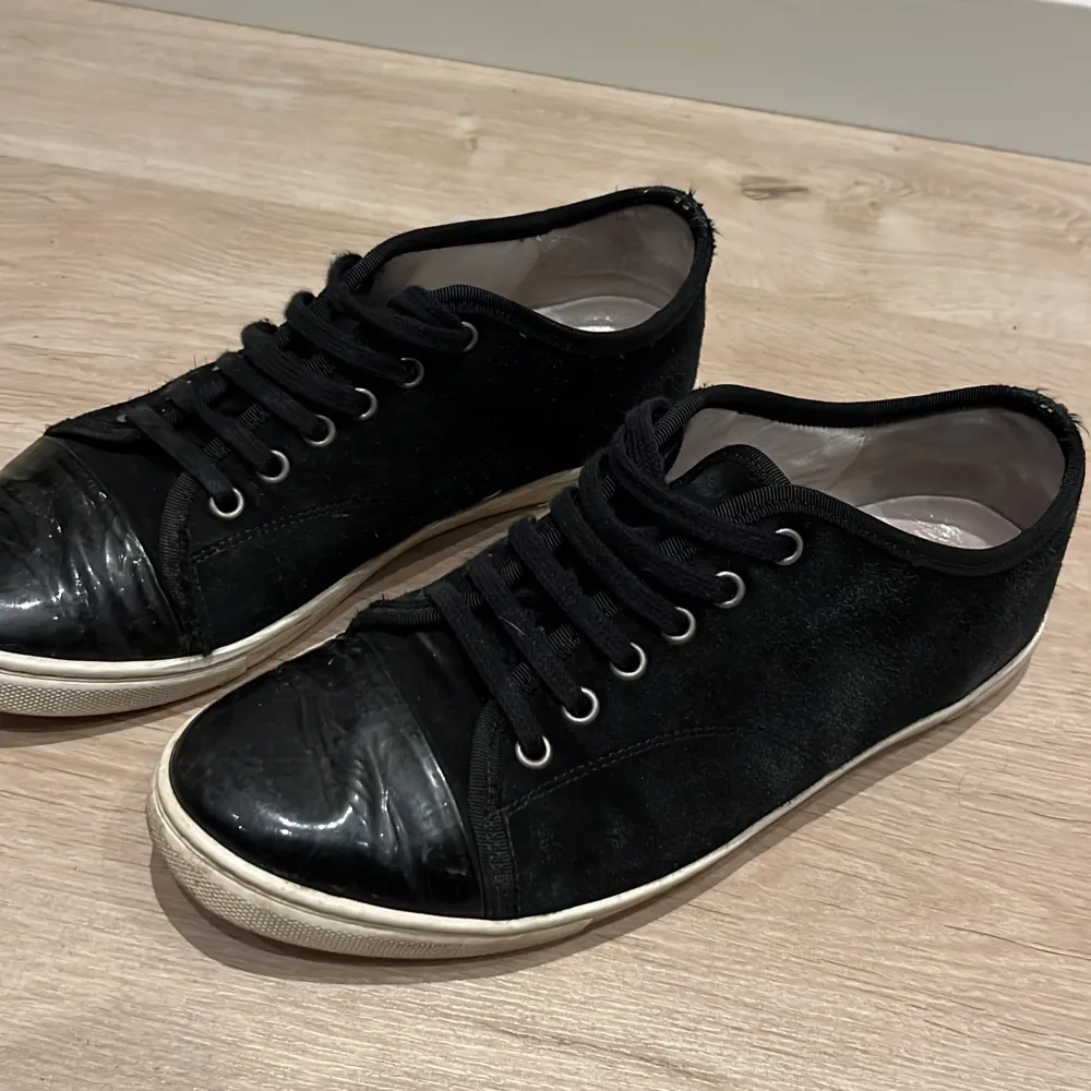 Säljer ett par svarta sneakers i bra skick. De har en snygg kombination av mocka och skinn med snörning framtill. Perfekta för vardagsbruk och passar till de flesta outfits. Sulan är vit och ger en cool kontrast till det svarta. Sköna och stilrena!. Skor.