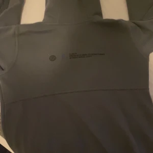 Grå hoodie från Hoodrich - Säljer en snygg grå hoodie från Hoodrich. Den har en stor logga på bröstet och en mindre på huvan. Perfekt för en avslappnad stil och passar bra till både jeans och joggers. Den är i bra skick och redo för nya äventyr!