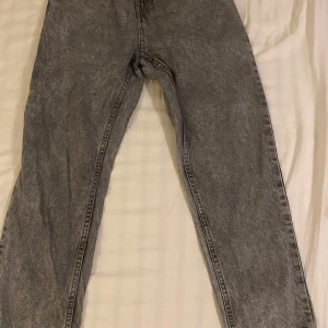Grå jeans från Grunt - Säljer ett par grå jeans från Gant i bra skick. De har en straight passform och är perfekta för både vardag och fest. Jeansen har en klassisk design med fem fickor och en dragkedja. Storlek 25, så de passar dig som gillar en tight fit. Perfekta för höst och vår! Passar 148-156. Aldrig använda bara testade