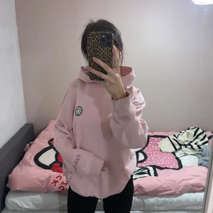 Rosa hoodie från H&M - Säljer en supermysig rosa hoodie från H&M i storlek S. Den har en cool design med ett tryck på ryggen och en liten patch framtill. Perfekt för chilliga dagar eller när du vill ha en avslappnad stil. Hoodien har en relaxed fit och är i bra skick. Passar perfekt till höst och vår! Oversized