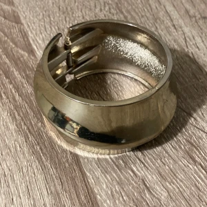 Guldfärgat armband - Snyggt guldfärgat armband i metall. Armbandet har en praktisk gångjärnsöppning som gör det enkelt att ta på och av. 