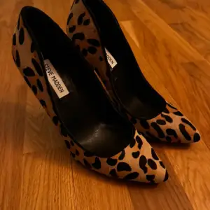 Snygga leopardmönstrade lackar från Steve Madden i mycket bra skick. De har en spetsig tå och hög klack, perfekta för en utekväll eller fest. Skorna är i syntetmaterial och har en cool och trendig look. Passar perfekt för att ge din outfit en extra edge!