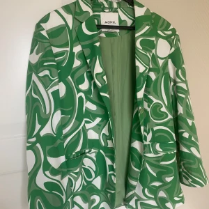 Grön och vit mönstrad kavaj från Monki - Säljer en supercool grön och vit kavaj från Monki med ett unikt mönster. Perfekt för att liva upp vilken outfit som helst! Kavajen har en normal passform och är långärmad. Den är i mycket bra skick och passar perfekt för vår och sommar. Denna är bara använd en gång, Harry styles konsert såklart!! Superfin! 
