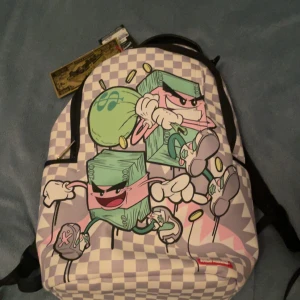 Rutig ryggsäck med tecknat motiv - Cool rutig ryggsäck från Sprayground med ett unikt tecknat motiv av springande sedelbuntar. Väskan har en dragkedja och en röd insida. Perfekt för att sticka ut i mängden!