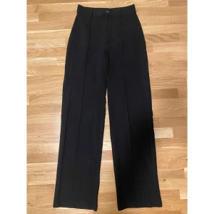 Svarta kostymbyxor från Pull&Bear - Snygga svarta kostymbyxor från Pull&Bear i storlek S. De har en klassisk design med hög midja och raka ben. 