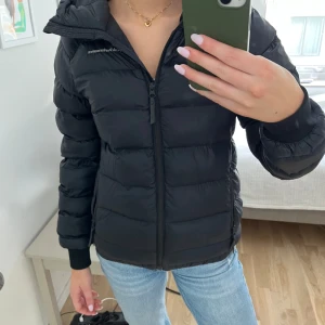 Svart dunjacka från Peak Performance  - Säljer en svart dunjacka från Peak Performance i mycket bra skick. Jackan har en dragkedja framtill och en mysig huva. Perfekt för kyliga höst- och vinterdagar. Den är långärmad och har en normal passform. Superbekväm och stilren!