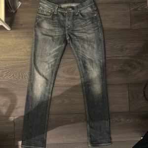 Blå jeans från Nudie Jeans - Säljer ett par snygga blå jeans från Nudie Jeans i storlek 31/32. De har en klassisk femficksdesign och en snygg tvättad look. Perfekta för både vardag och fest! 🕺