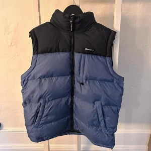 Blå och svart dunväst från Champion - Säljer en snygg blå och svart dunväst från Champion i storlek M. Inköpt på Vinted men passade tyvärr inte mig🥹 den förra ägaren har dock tagit väl hand om den så inga tecken på slitage. 