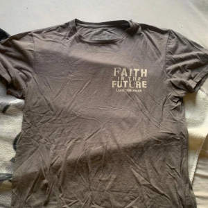 Louis tomlinson europe merch 'Faith in the Future' - Säljer  t-shirt från Louis Tomlinson med texten 'Faith in the Future' på framsidan och 'World Tour 2023' med turnédatum på baksidan. T-shirten är i bomull och har en liten reva i armhålan inte alls synlig . Perfekt för fans av Louis Tomlinson!