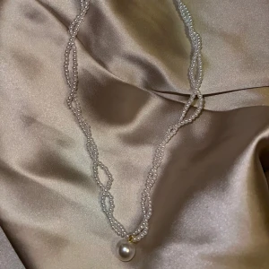 Elegant pärlhalsband med hänge - Säljer ett supervackert halsband med små vita pärlor och ett större pärlhänge. Perfekt för att ge en touch av elegans till vilken outfit som helst. Halsbandet är i mycket bra skick och passar både till vardags och fest. Ett måste för pärlälskare! ✨