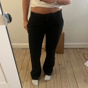 Svarta kostymbyxor - Säljer ett par svarta kostymbyxor i mycket bra skick. De är lågmidjade och är i bra skick, de är använda fåtal ggr och säljer för jag har ett par till kostymbyxor. Byxorna har knappar och dragkedja framtill. Lite slitningar längst ned till på benen, inte som man tänker på💗