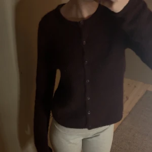 Mörkröd kofta med knappar  - Säljer en mysig mörkröd kofta med knappar framtill. Perfekt för höst och vinter, den är långärmad och har en klassisk design som passar till det mesta. Superfin att ha över en t-shirt eller blus 🍾 från Gina tricot 