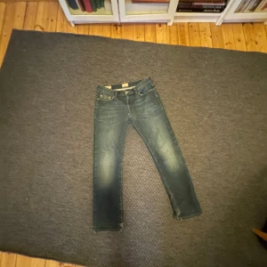 Blå jeans från Boss Orange - Säljer ett par snygga blå jeans från Boss Orange i regular fit. De är i bra skick och perfekta för vardagsbruk. Klassisk design med fem fickor och knappgylf. Passar både till avslappnade och mer uppklädda tillfällen.