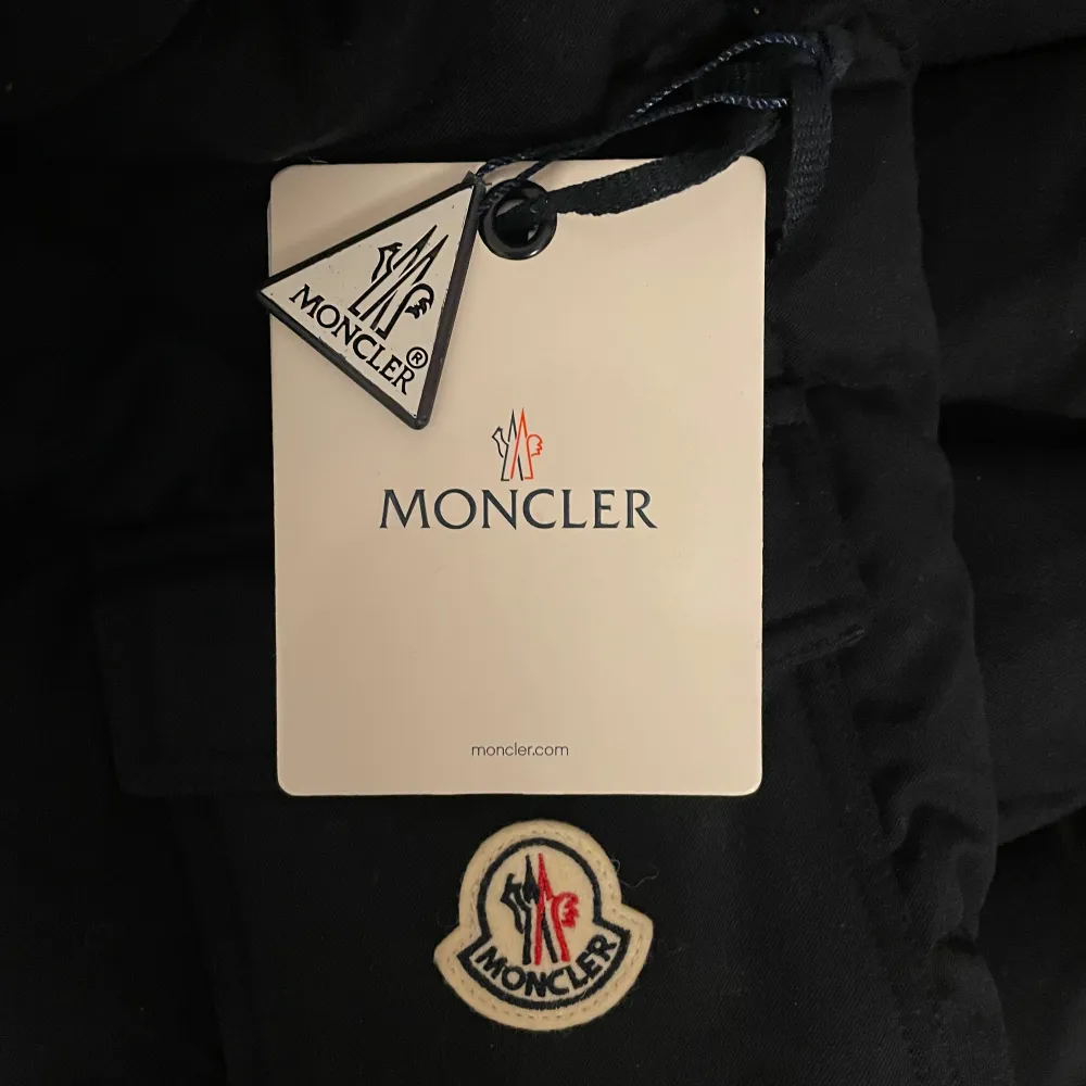 Säljer en snygg svart dunjacka från Moncler i mycket bra skick. Jackan har en dragkedja framtill och en huva för extra värme. Perfekt för kalla vinterdagar. Den är långärmad och har en klassisk Moncler-logga på ärmen. Passar både till vardags och festliga tillfällen. För fler bilder/frågor, så skriv!😁. Jackor.