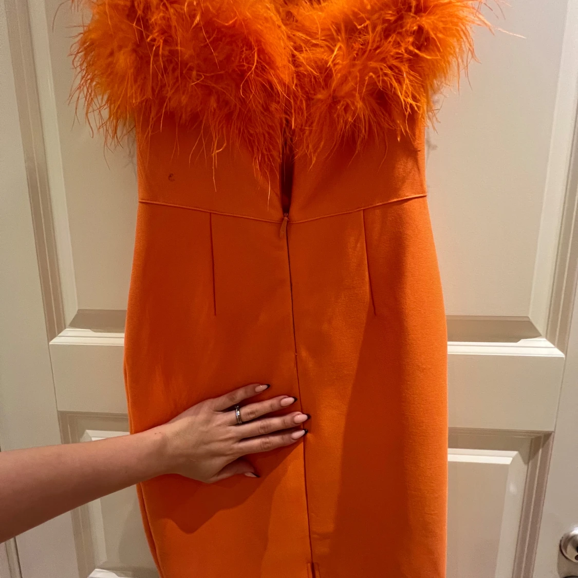 Orange klänning med fjäderdetaljer - 91