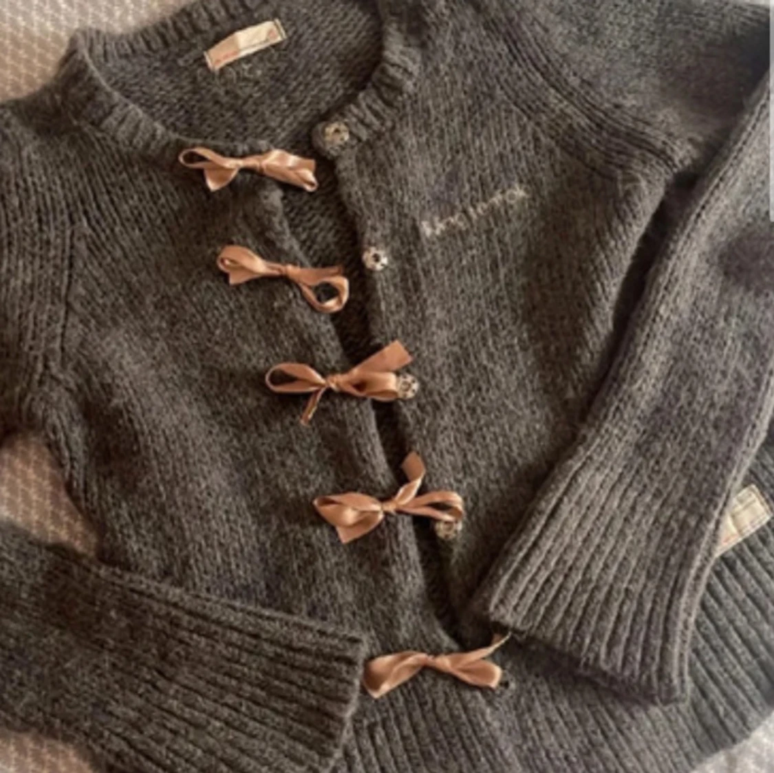 Grå stickad kofta med rosetter