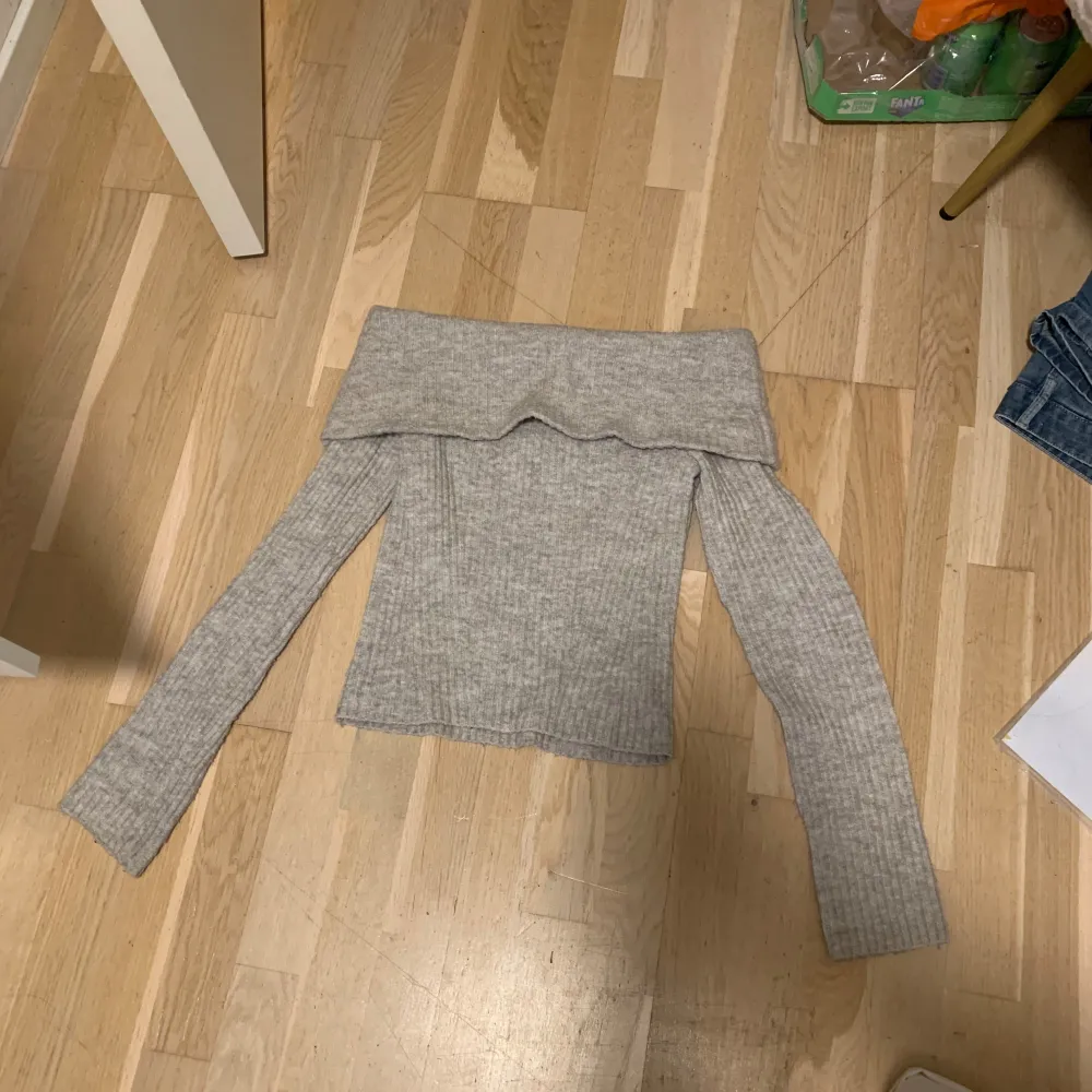 Säljer en superfin grå offshoulder tröja från H&M. Den är stickad och perfekt för höst och vinter. Tröjan har långa ärmar och en mysig, ribbad design. Perfekt för att hålla sig varm och stilren under kyliga dagar. 🧣✨. Stickat.