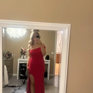 Röd axelbandslös klänning - Säljer en exakt lika dan balklänning fast i en storlek större från Club L. Klänningen på  bilden är i storlek 8uk den andra är i storlek 10uk och klassas som en M i Sverige. 