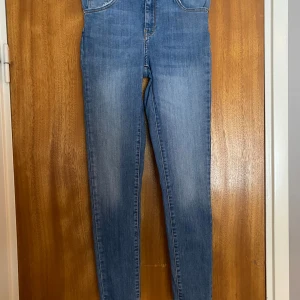 Blå jeans från Never Denim strl XS - Säljer ett par snygga blå jeans från Never Denim i storlek XS. De är högmidjade och har en skinny passform som sitter perfekt. Jeansen är i bra skick och passar både till vardags och fest. Perfekta för höst och vår! 84,5% Bomull 13,5% Polyester 2% Elastan. Modellen heter JP Higher Ella 52