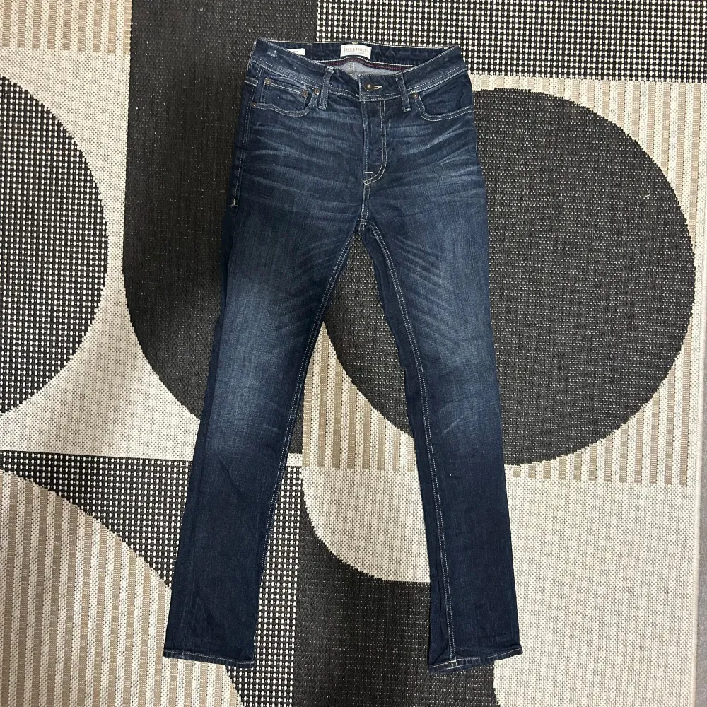 Säljer ett par snygga mörkblå jeans i slim fit-modell. De har en klassisk femficksdesign och är perfekta för både vardag och fest. Jeansen är i bra skick och har en bekväm passform. Perfekta för höst och vår!. Jeans & Byxor.